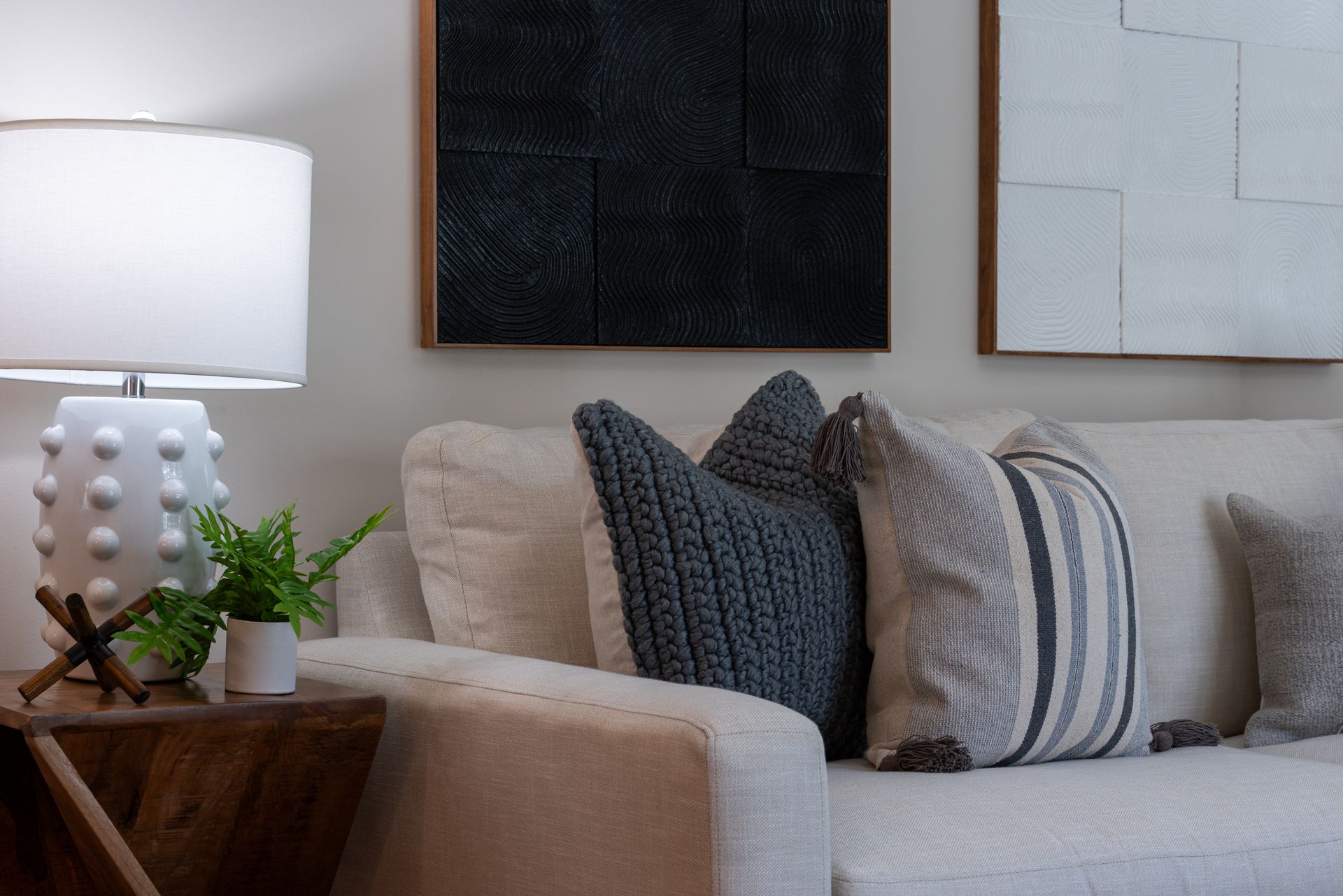 Stock photo of a couch with a table next to it. On the table is a lamp.