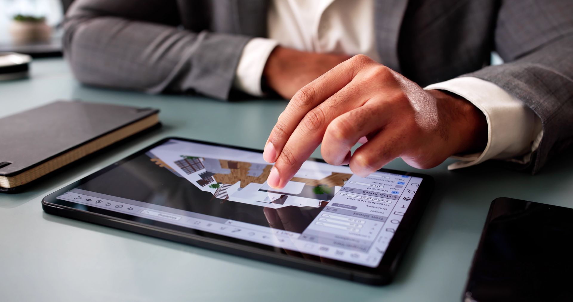 Personne utilisant une tablette, modifiant un plan de conception architecturale.