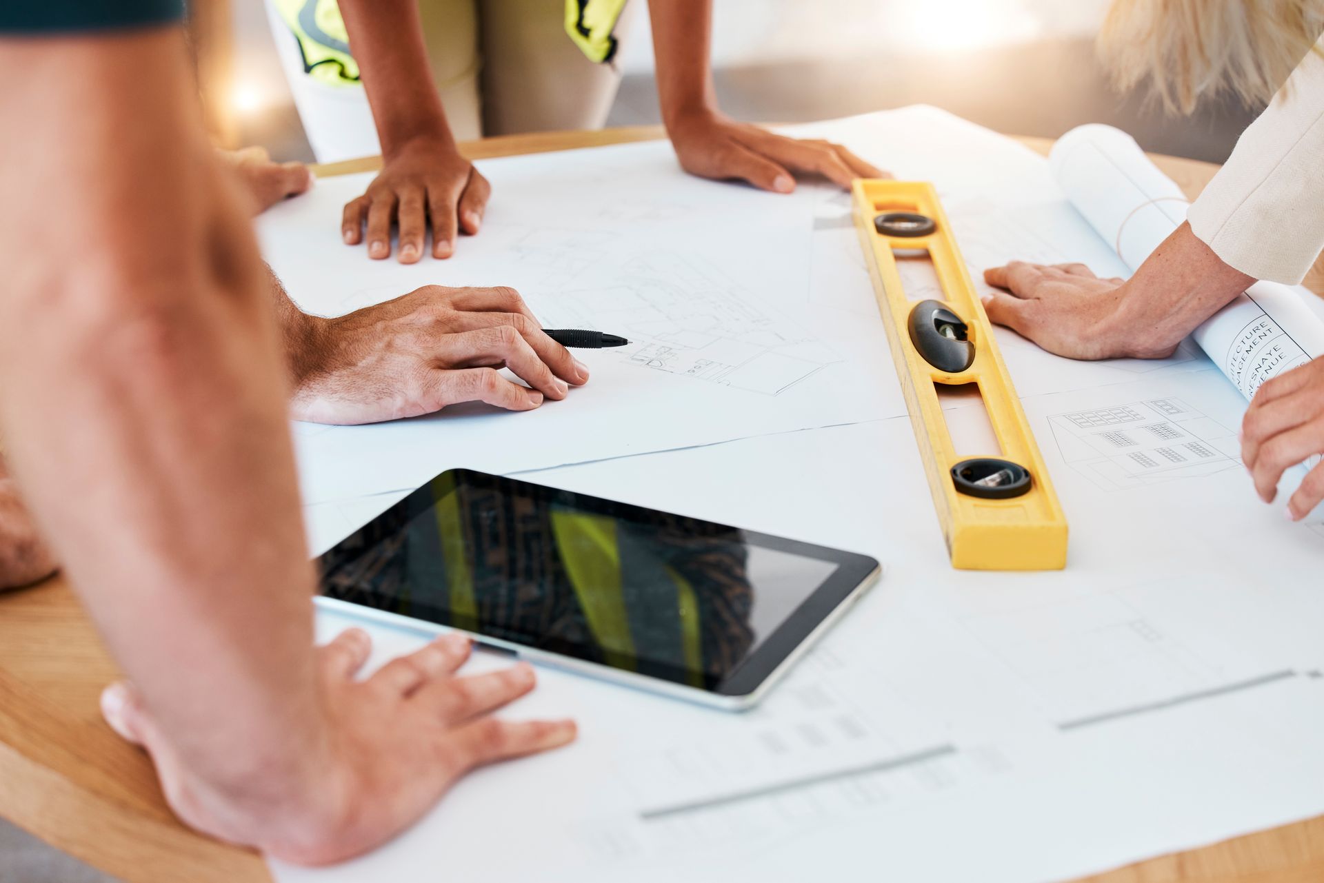 Un groupe de personnes est assis autour d'une table et regarde des plans.