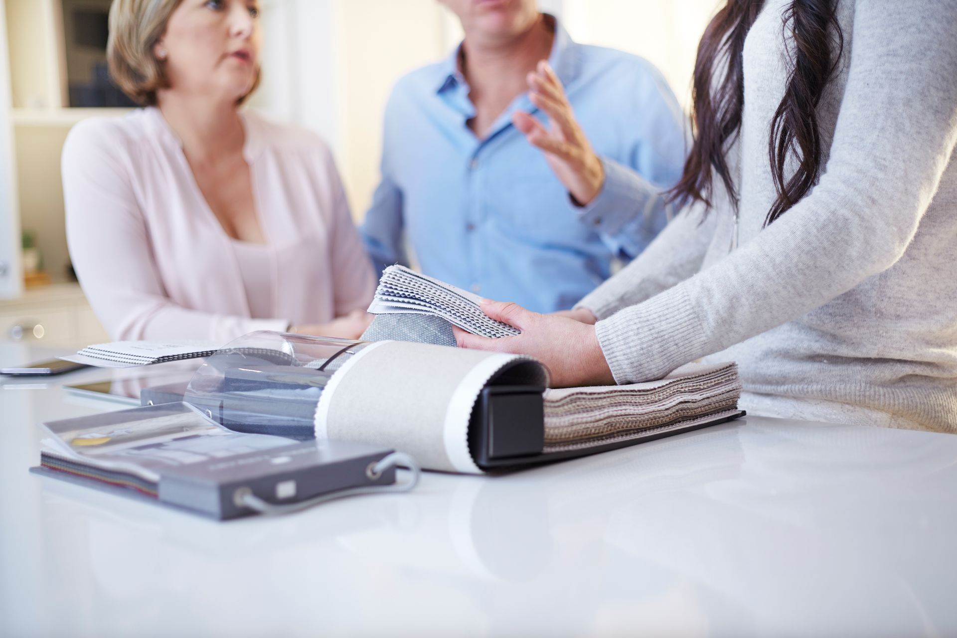 Un groupe de personnes sont assises à une table et regardent des tissus.