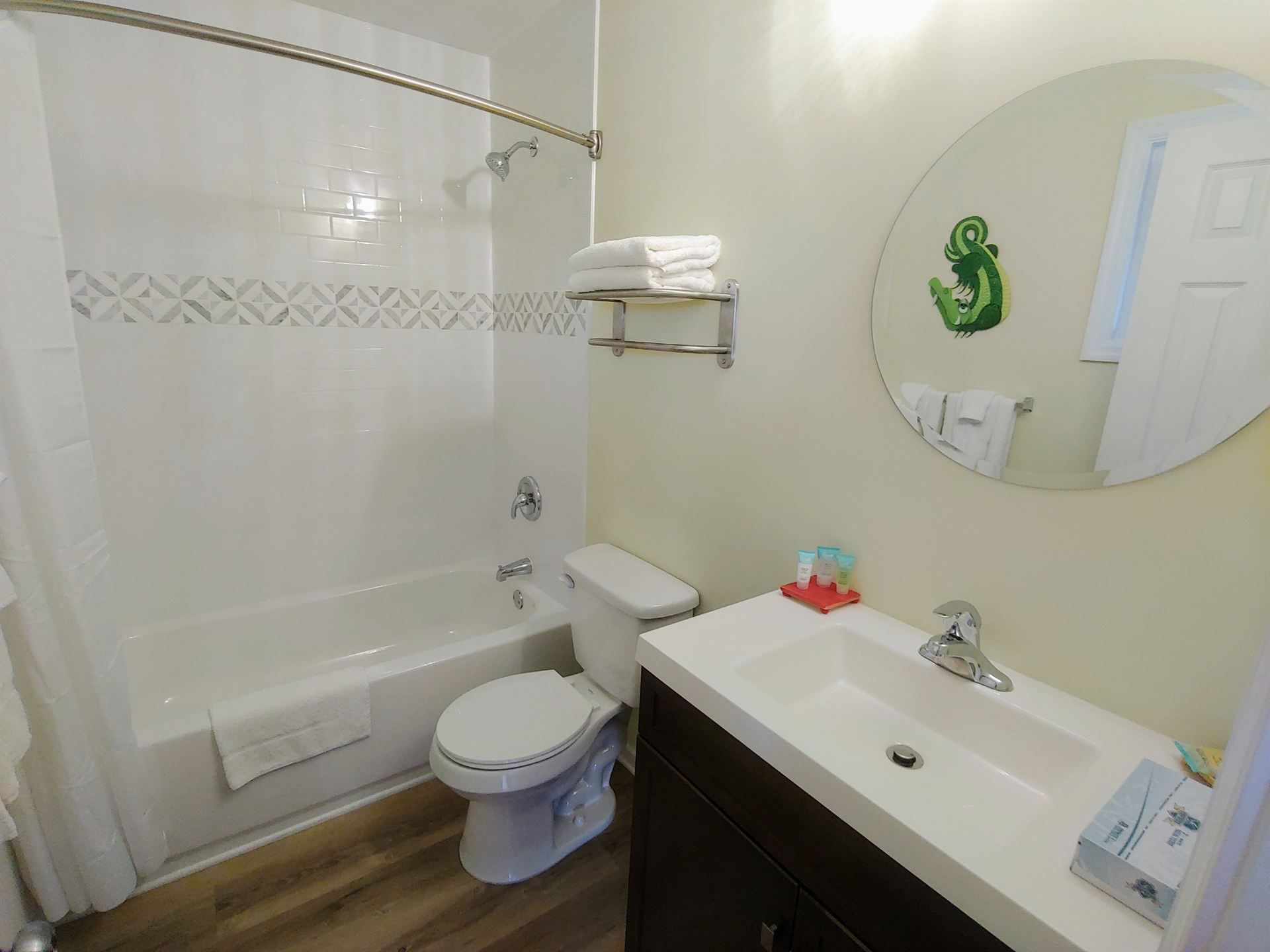 A bathroom with a toilet , sink , tub and mirror.