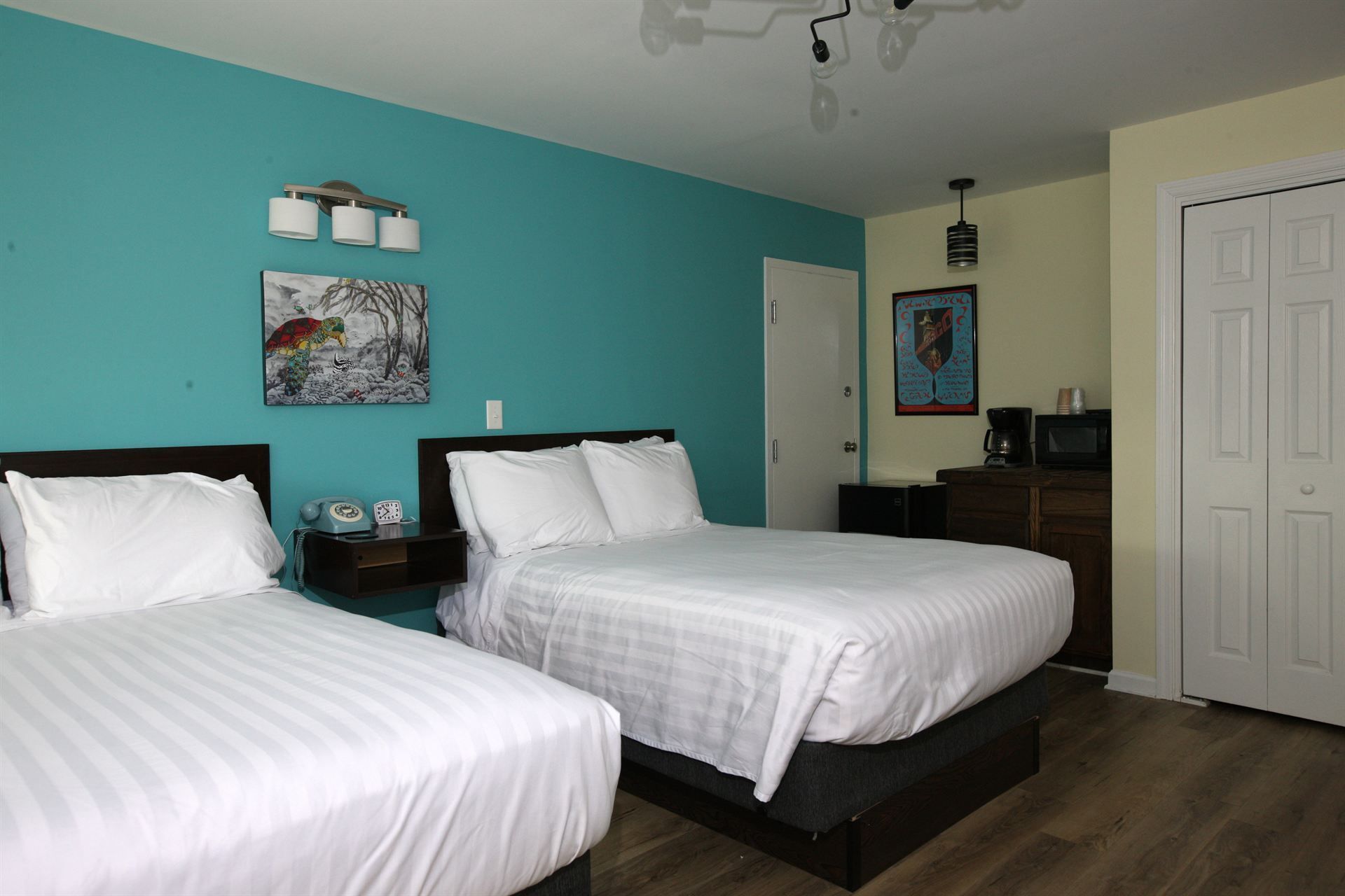 A hotel room with two beds and a blue wall.