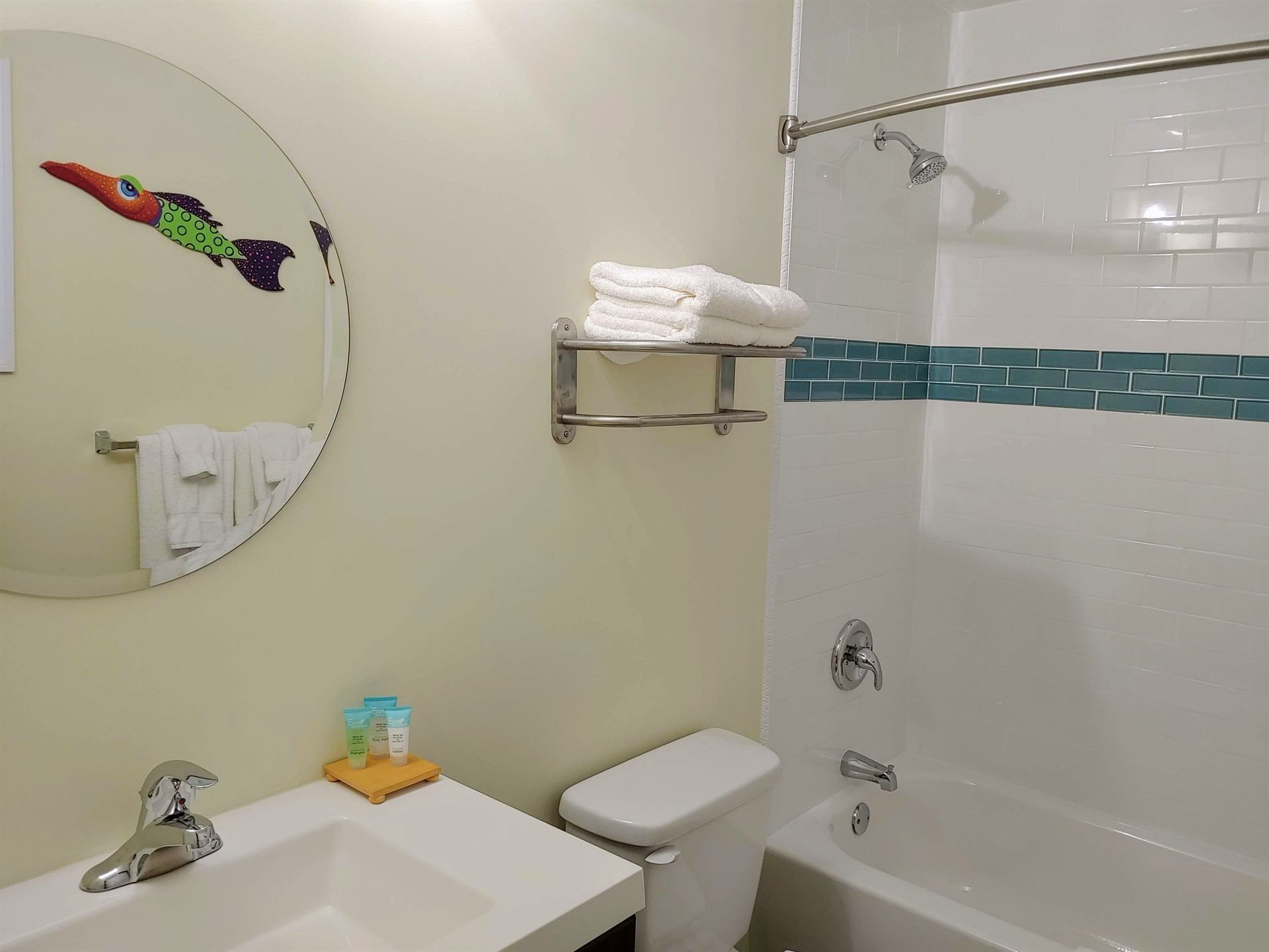 A bathroom with a sink , toilet , bathtub and mirror.