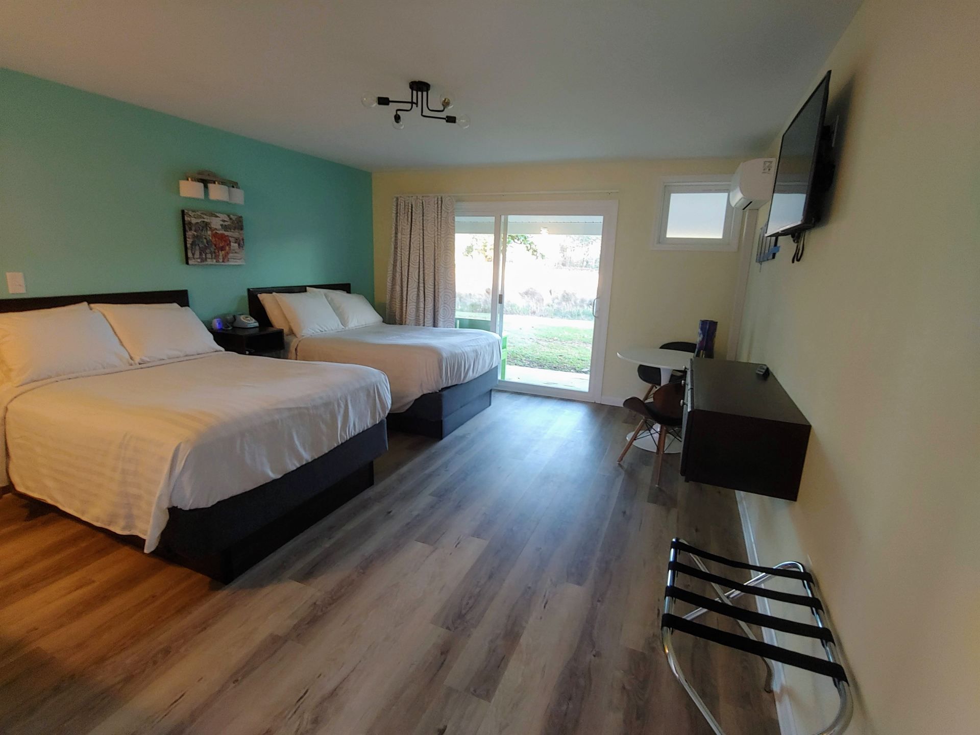 A hotel room with two beds and a flat screen tv.