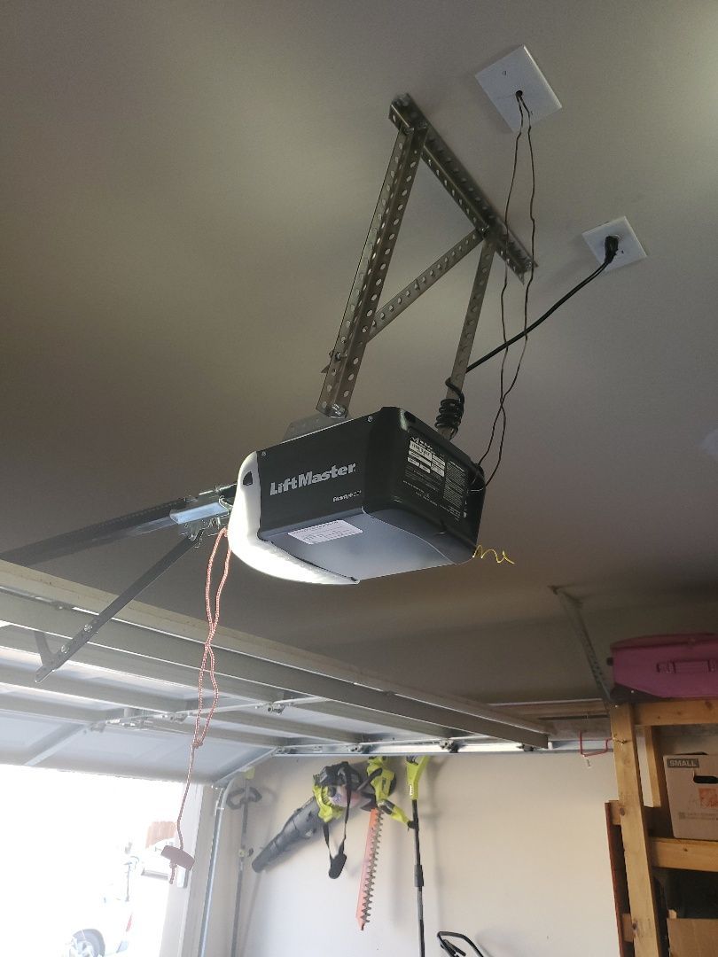 Garage door opener mounted on the ceiling with chain drive.