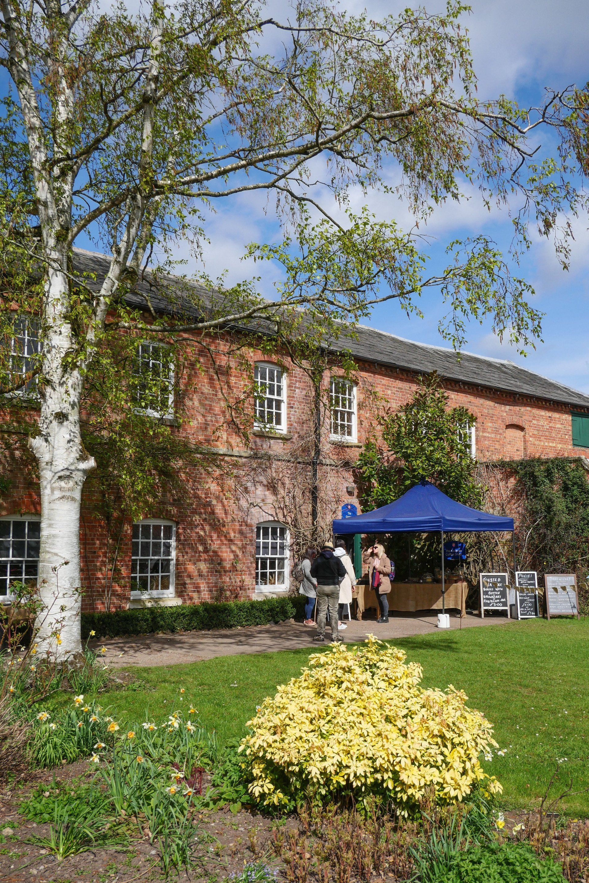 A group of people are standing in front of a large brick building.