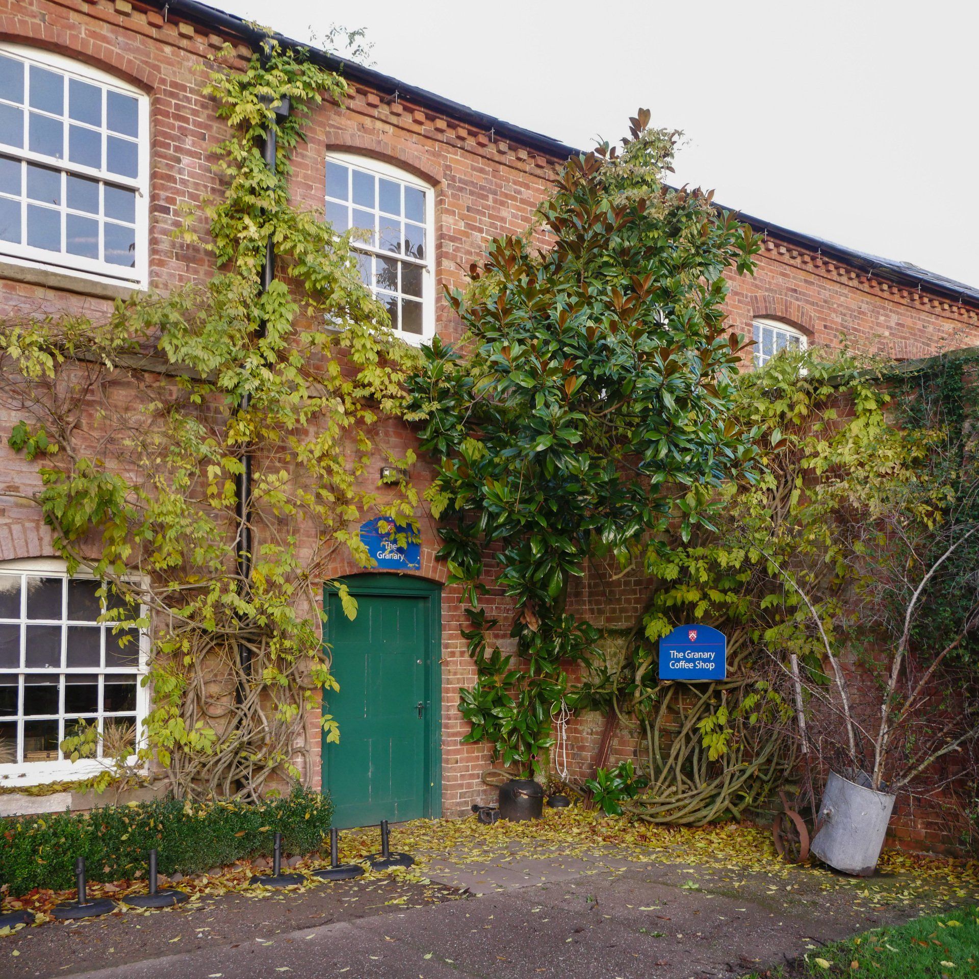 A brick building with a green door and a sign that says ' a ' on it