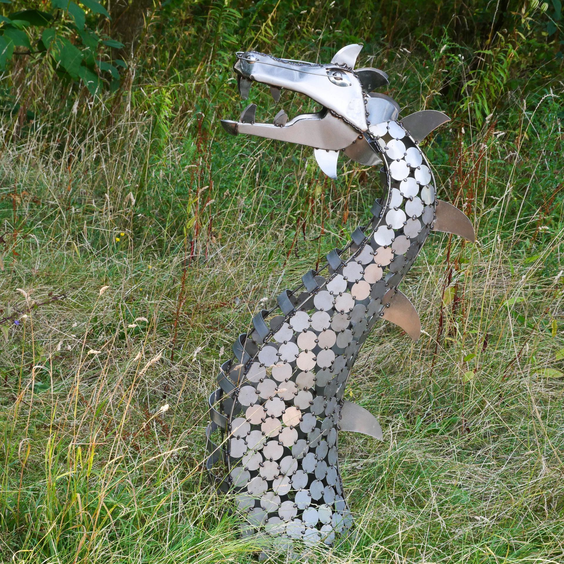 A statue of a dragon is sitting in the grass