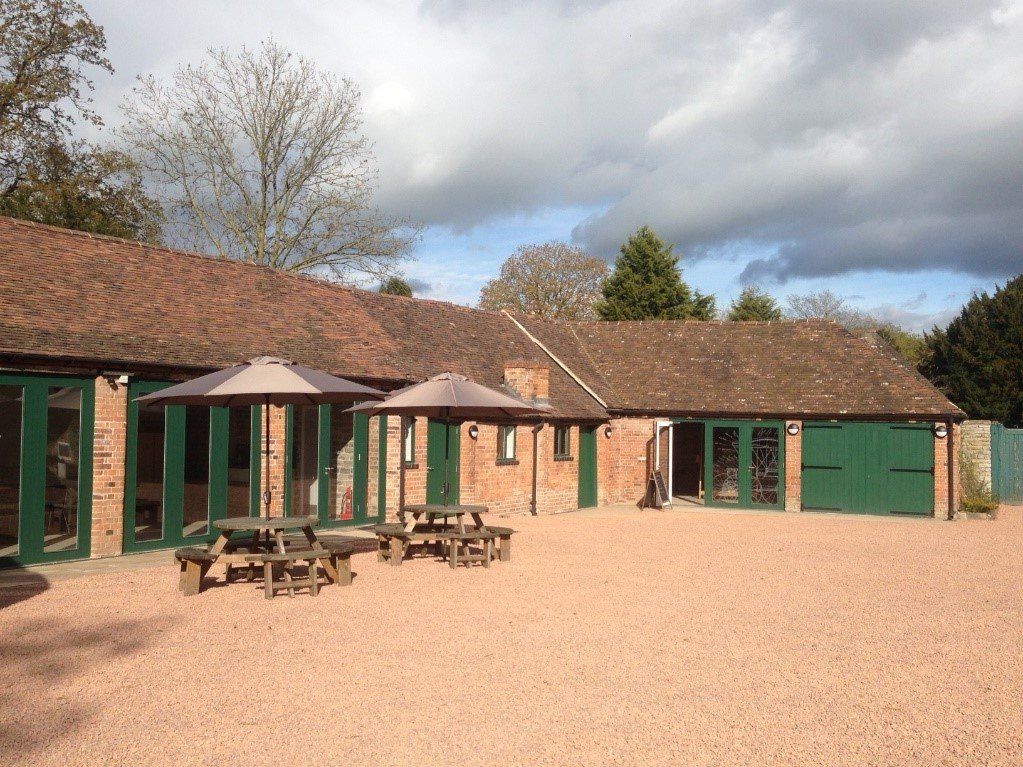A large building with green doors and umbrellas in front of it