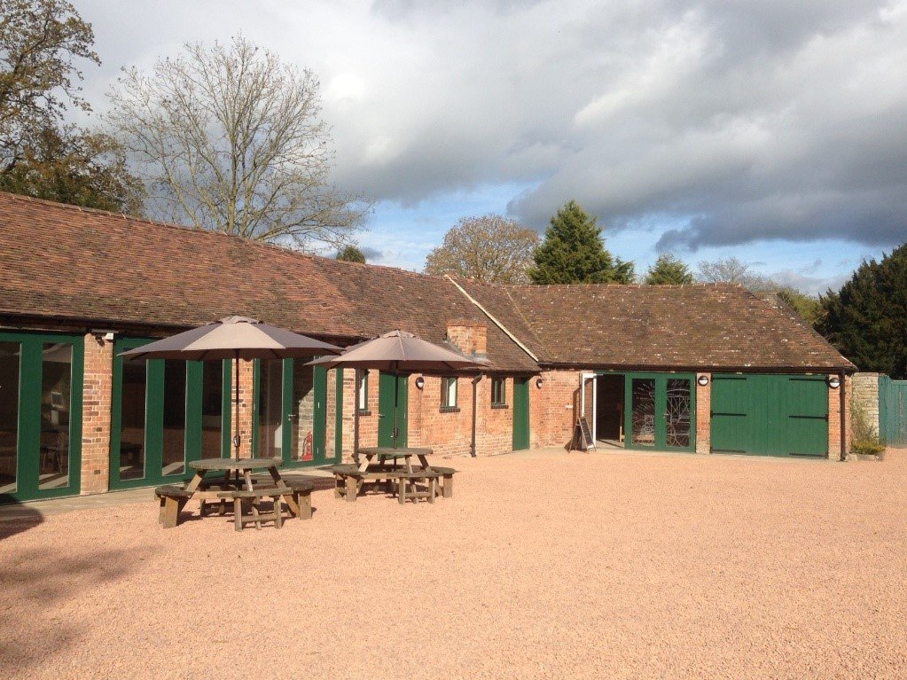 A large building with green doors and umbrellas in front of it