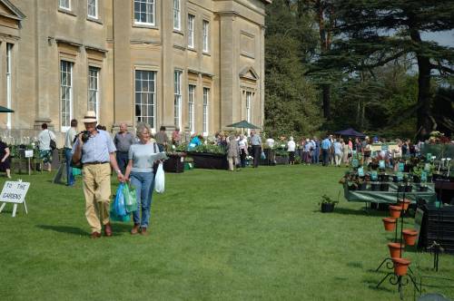 A group of people are walking in front of the main house
