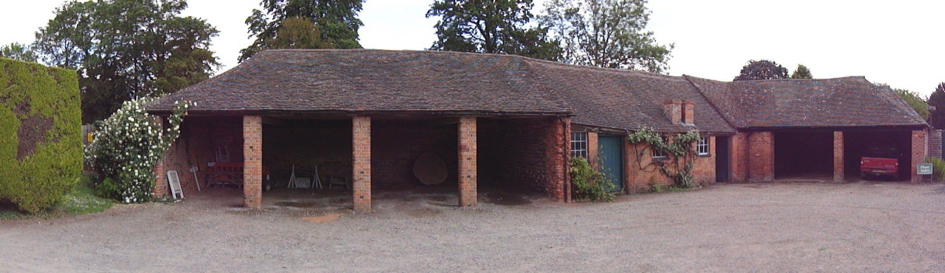 A row of buildings with a gravel driveway in front of them