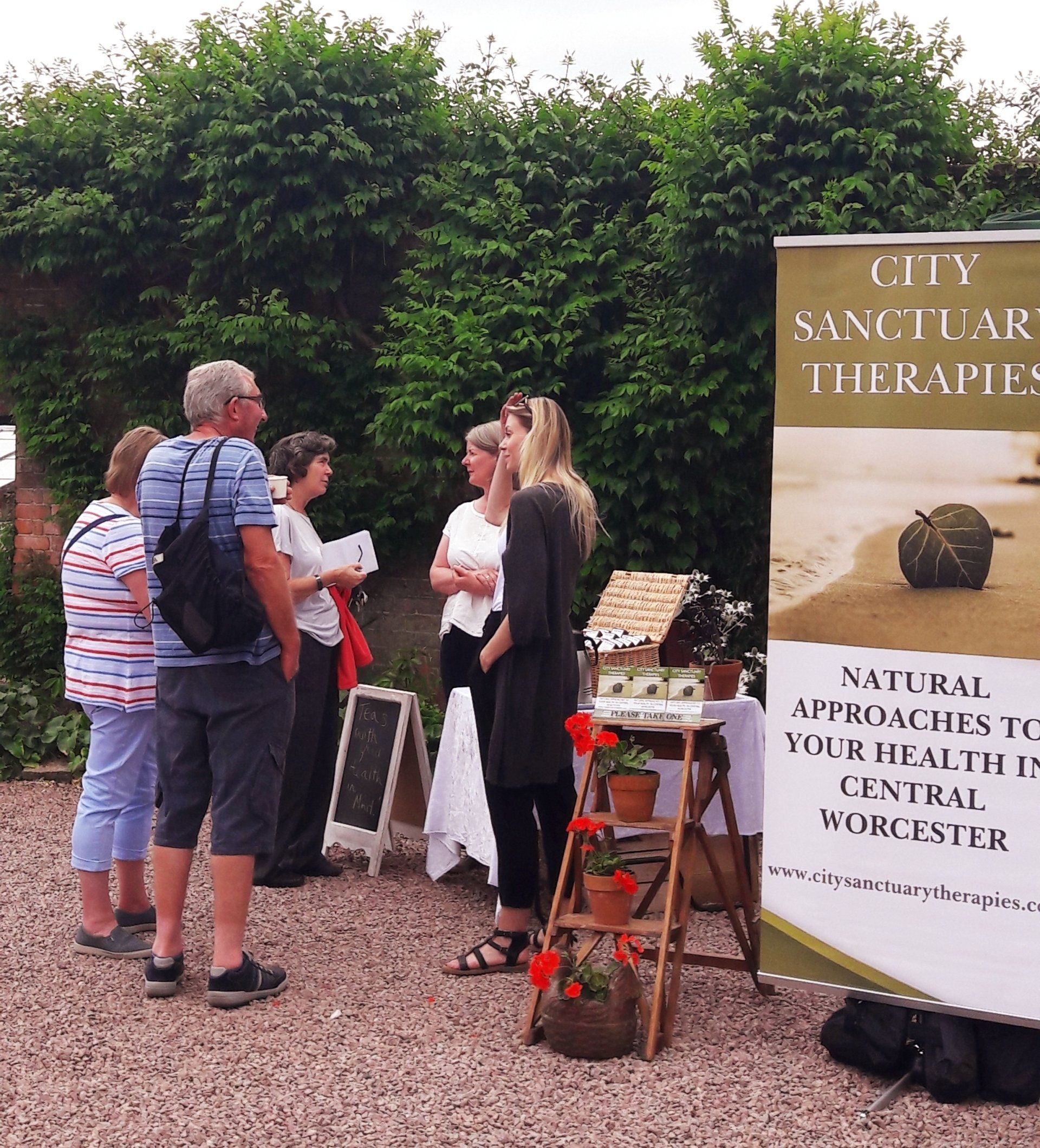 A group of people standing in front of a sign that says city sanctuary therapies