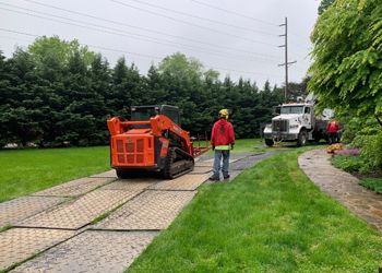 A man is standing next to a bulldozer on a dirt road.