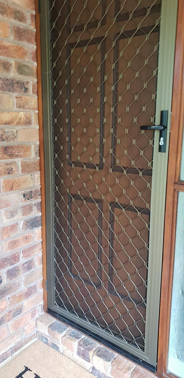 A Screen Door is Sitting on a Porch Next to a Brick Wall — North Coast Screens & Repairs in Goonellabah, NSW