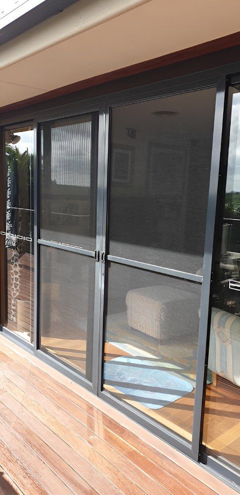A Living Room With Sliding Screen Doors — North Coast Screens & Repairs in Byron Bay, NSW
