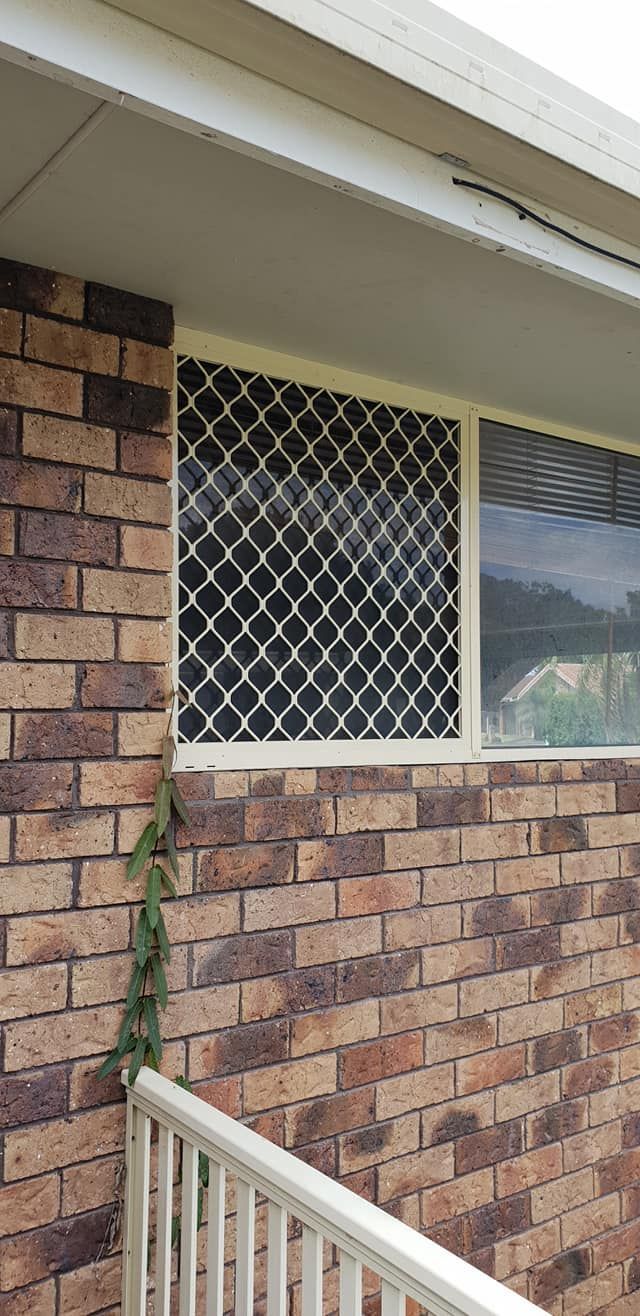 A Brick Building With a Window and a White Screen — North Coast Screens & Repairs in Ballina, NSW