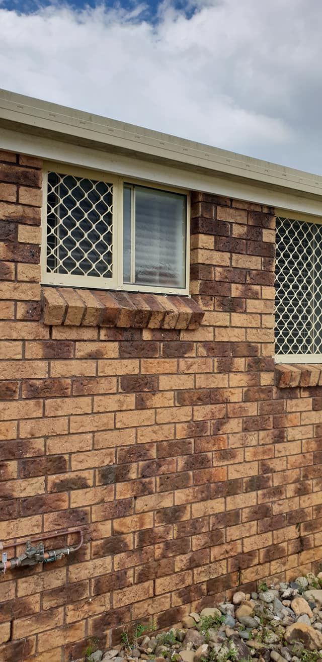 A Brick Building With a Screened Window on the Side of It — North Coast Screens & Repairs in Byron Bay, NSW