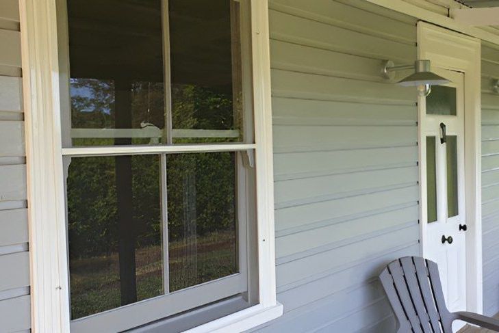 A Porch With a Chair and a Screened Window on the Side of a House — North Coast Screens & Repairs in Byron Bay, NSW