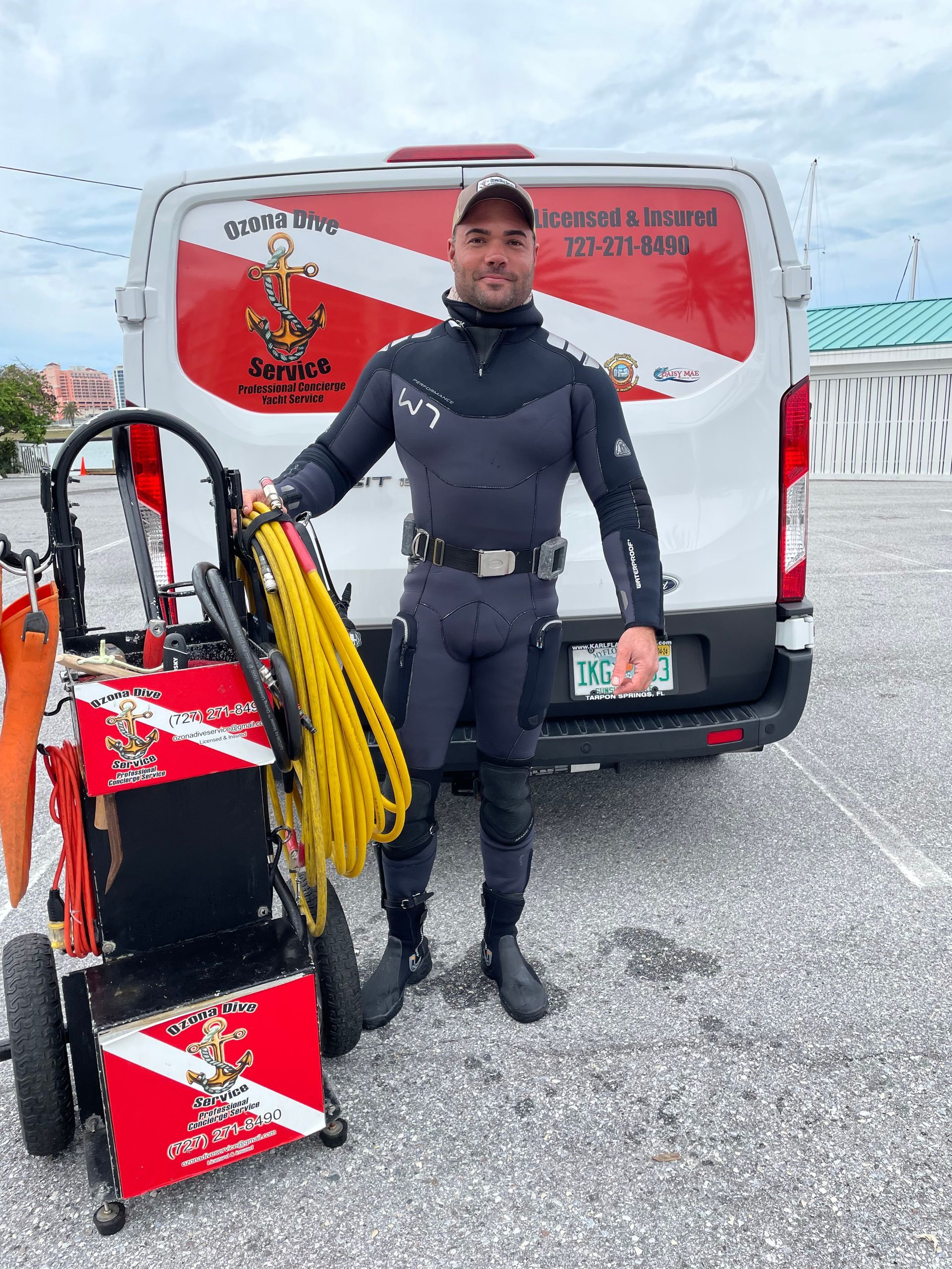 A Man in a Diving Suit is Standing Beside His Tools — Palm Harbor, FL — Ozona Dive Service