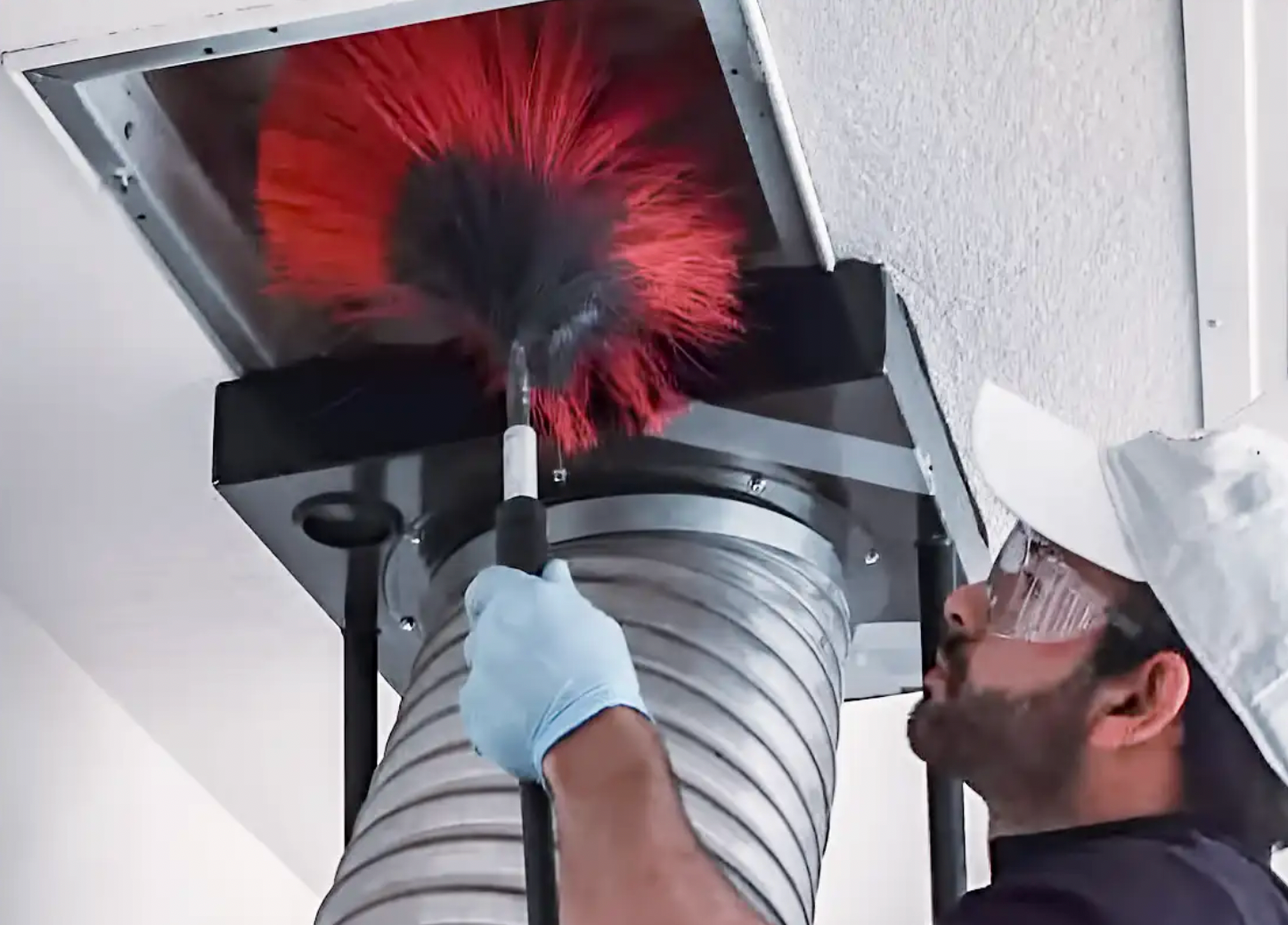 A close up of a dirty air duct with a hole in the middle.