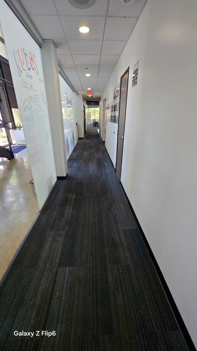 A person is using a vacuum cleaner to clean a carpet in a bedroom.