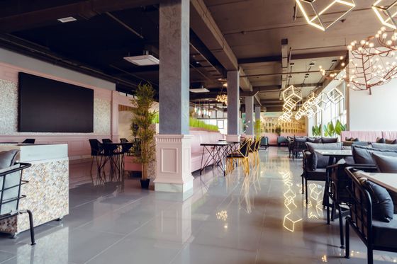 Two men are cleaning an office with a vacuum cleaner.