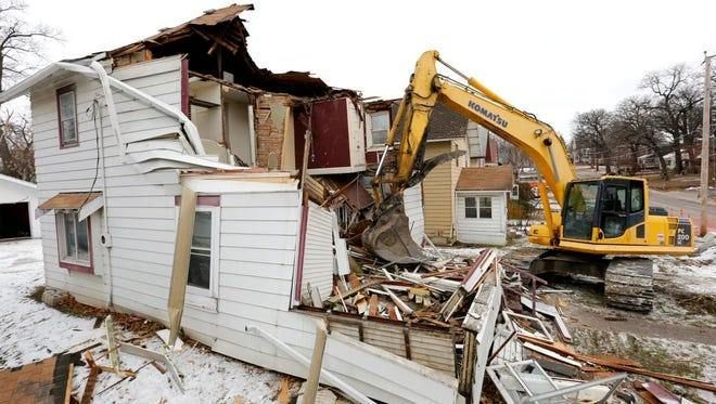 A person holding a baby up in the air indoors near a window, baby smiling.