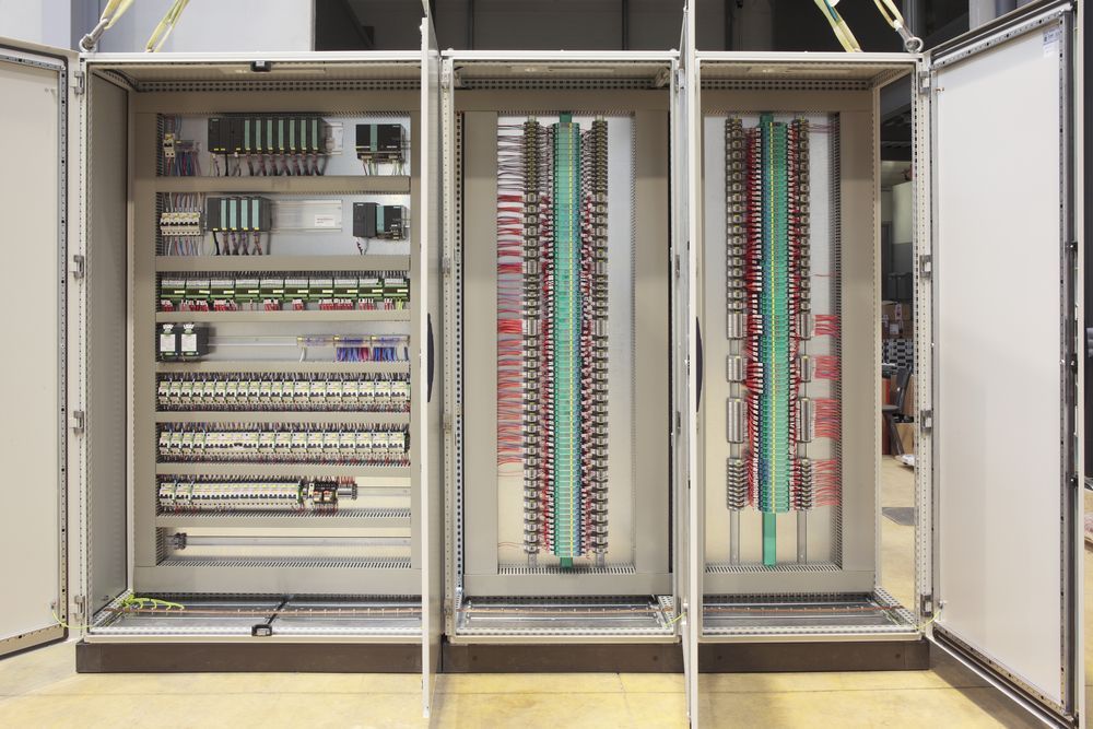 A row of electrical cabinets with the doors open