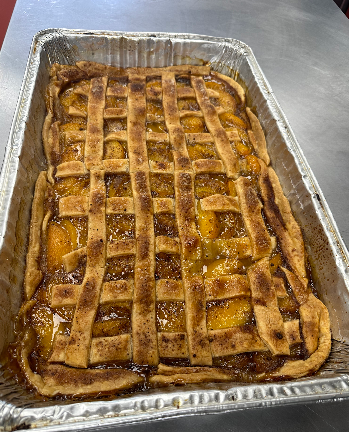 A pie in a tin foil pan on a table.