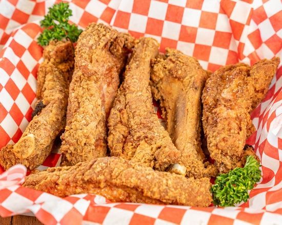 A basket of fried chicken wings on a checkered paper.