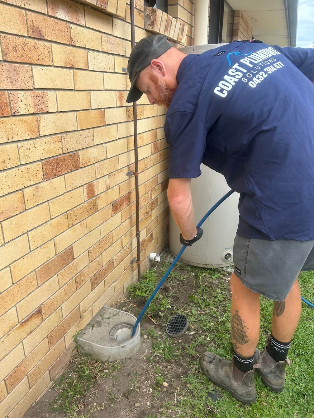 Pressure washer cleaning a brick paver walkway, revealing a cleaner section.