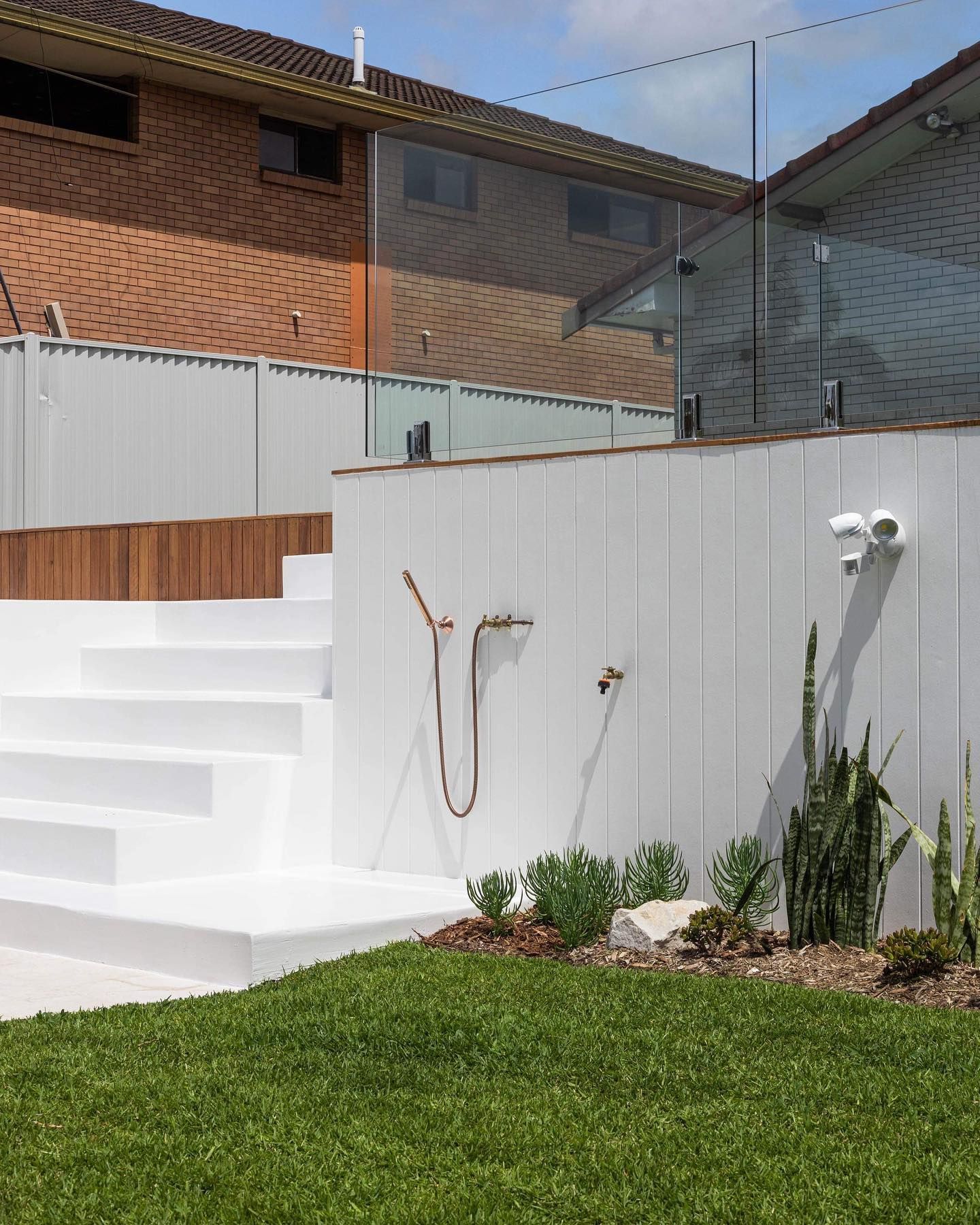 Modern bathroom with white walls, patterned floor tiles, and a wooden vanity.