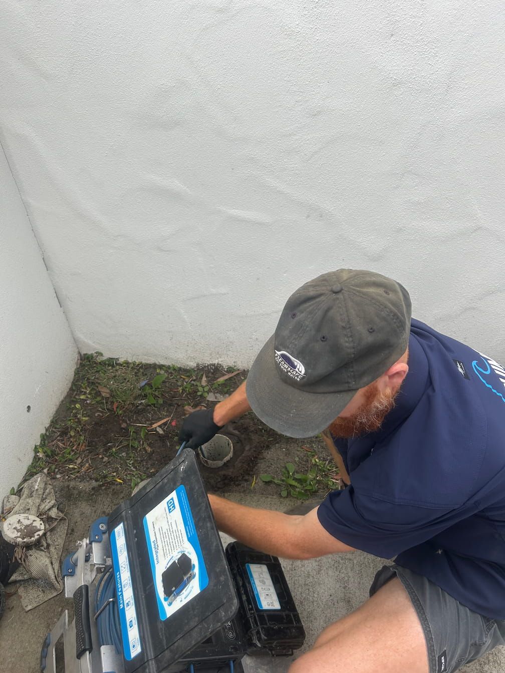 Plumbing system with filters, gauges, and pipes mounted on a wooden board against a wall.