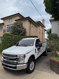 White Ford F-350 truck parked on a driveway in front of a two-story beige house.