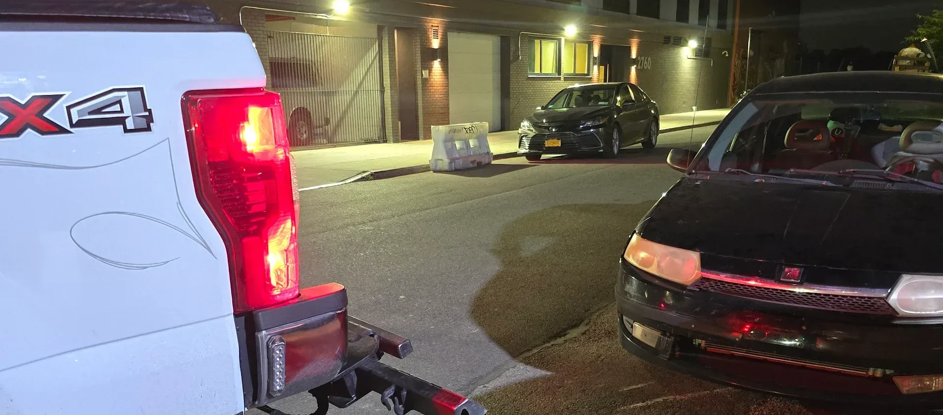 White towing small black car with dolly