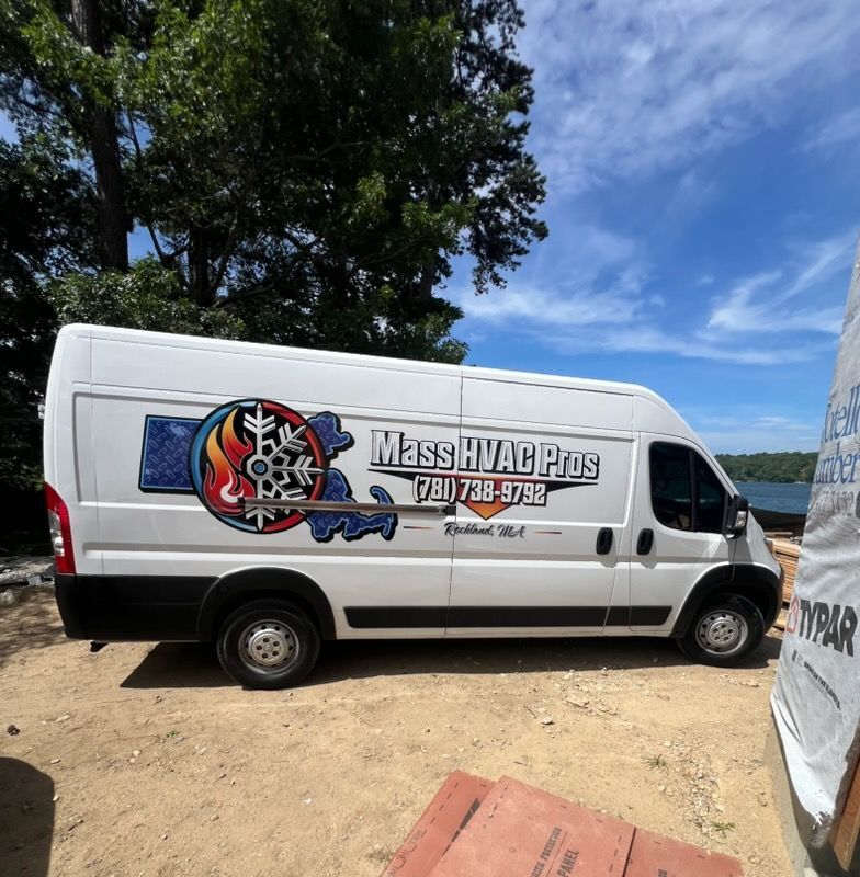 White MassHVacPros service van parked on dirt road under trees, with logo and phone number on side