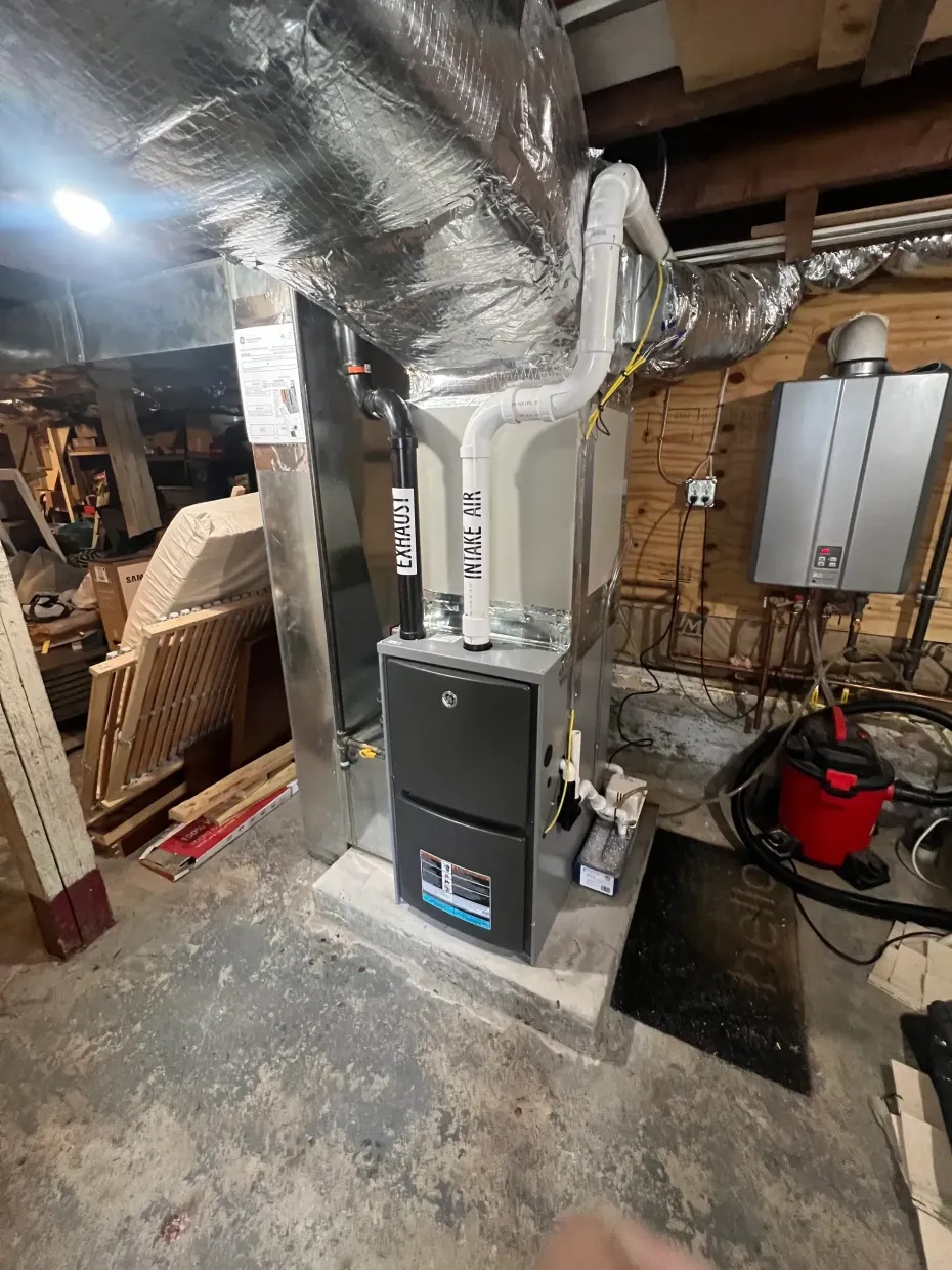 A modern furnace and tankless water heater installed in a residential basement.
