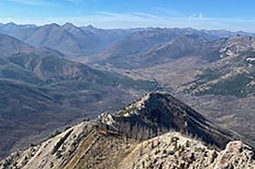 A view of a mountain range from the top of a mountain.