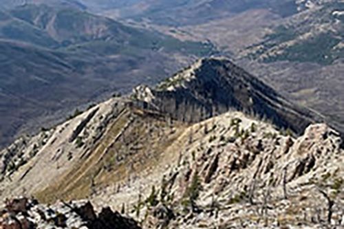 A view of a mountain range from the top of a mountain.