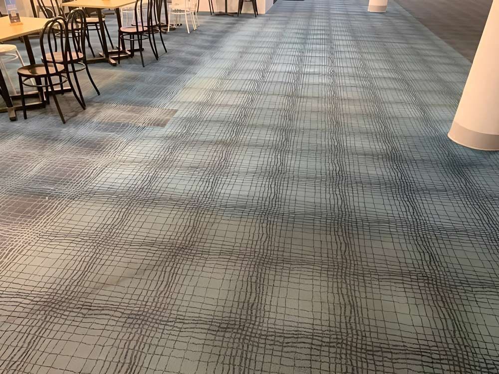 A Blue Carpeted Floor With Tables And Chairs In A Restaurant — Dryology Carpet Cleaning in Hamilton, NSW