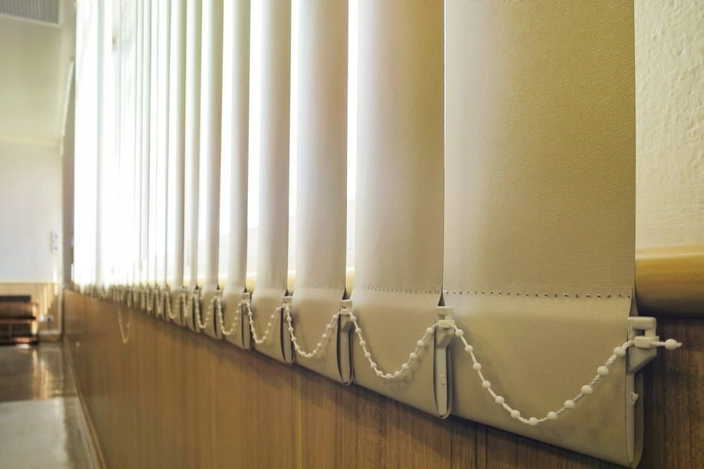 A row of vertical blinds on a wall in a hallway — Dryology Carpet Cleaning in Salamander Bay, NSW