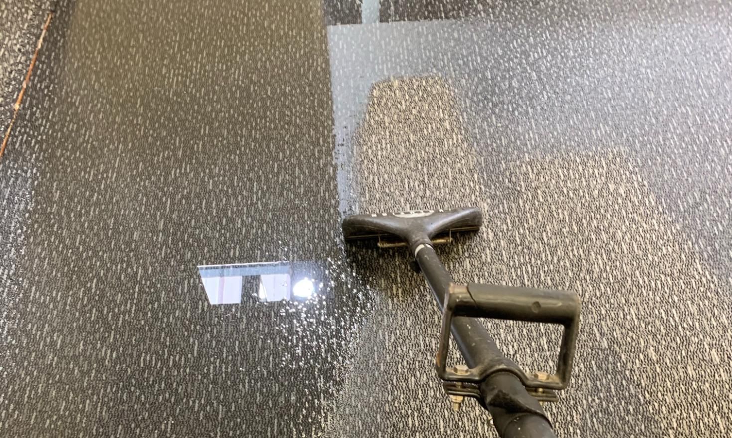 A person is cleaning a textured floor with a vacuum — Dryology Carpet Cleaning in Salamander Bay, NSW