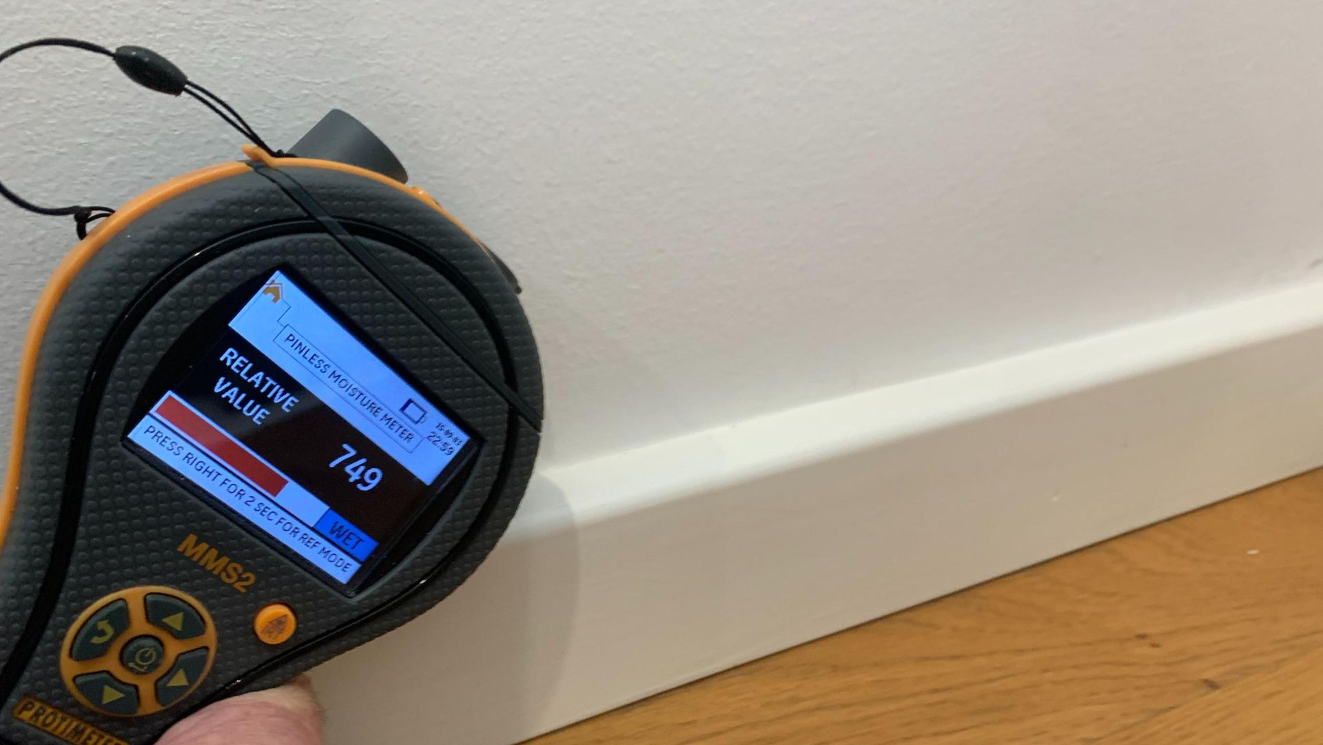 A moisture meter against a white baseboard; close-up indoors — Dryology Carpet Cleaning in Salamander Bay, NSW