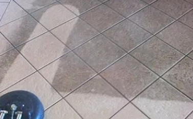 A close up of a tiled floor with a shadow of a person on it — Dryology Carpet Cleaning in Salamander Bay, NSW