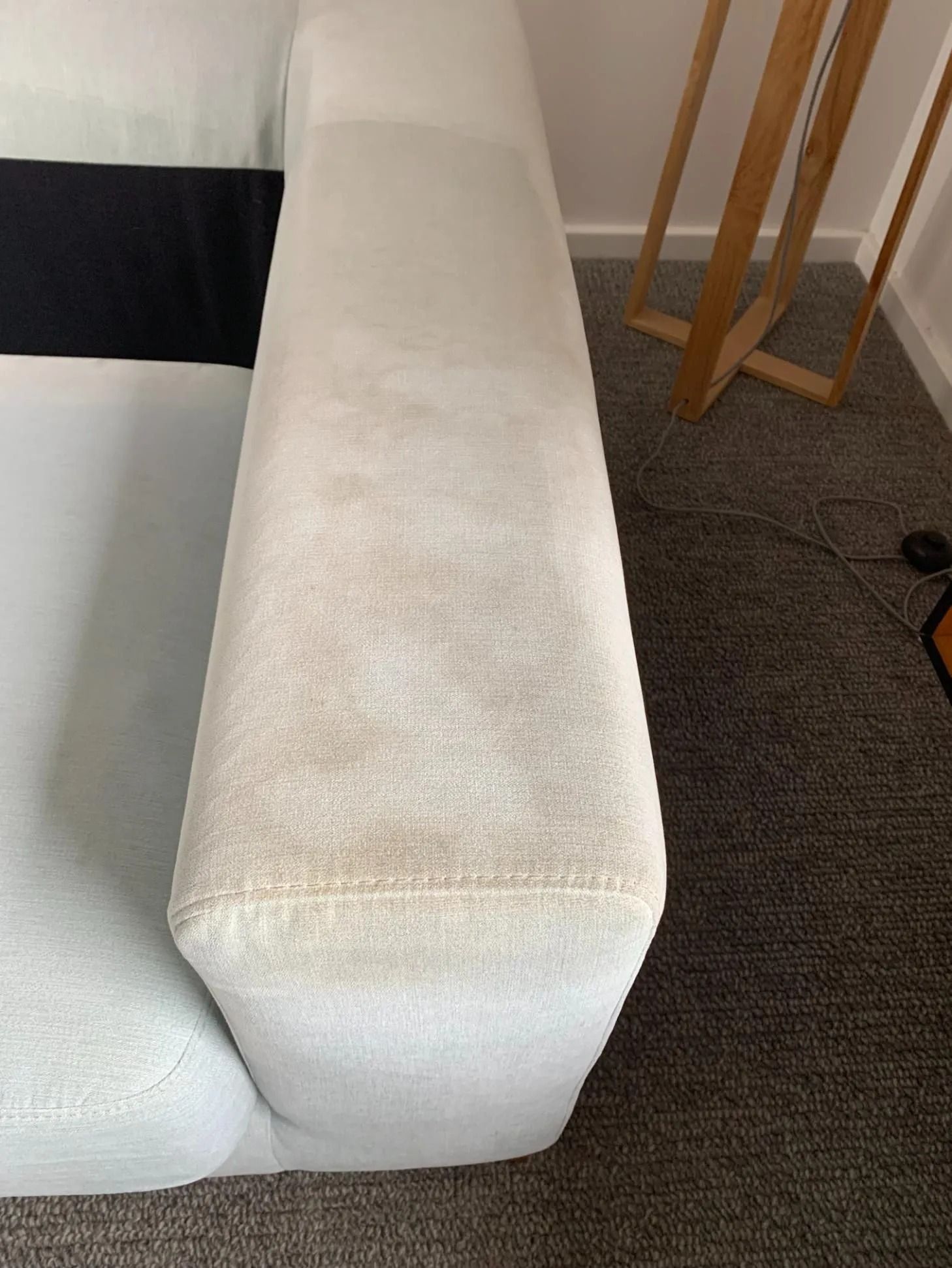 White Sofa Arm With Visible Stains on a Gray Carpet — Dryology Carpet Cleaning in Merewether, NSW