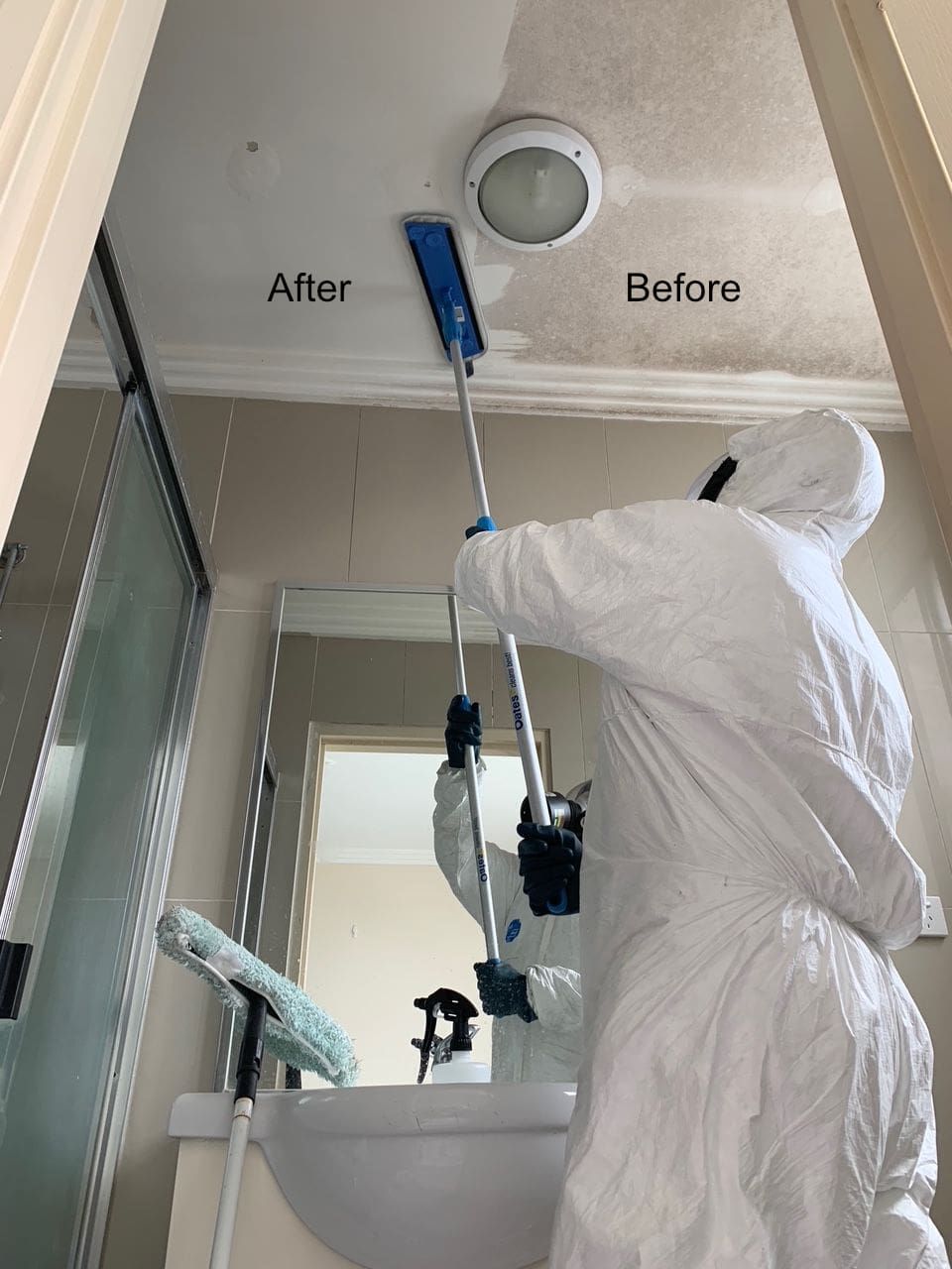 A person in a protective suit is cleaning a bathroom ceiling — Dryology Carpet Cleaning in Salamander Bay, NSW