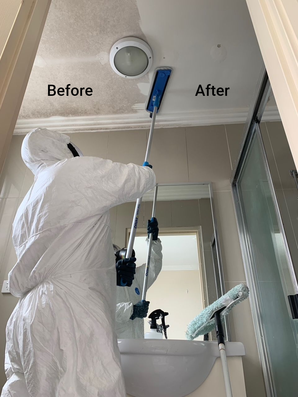 Person in Protective Suit Cleaning a Moldy Bathroom Ceiling — Dryology Carpet Cleaning in Rutherford, NSW
