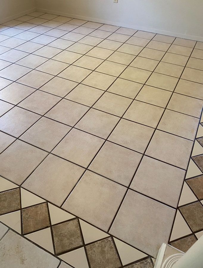Beige tiled floor with decorative border.