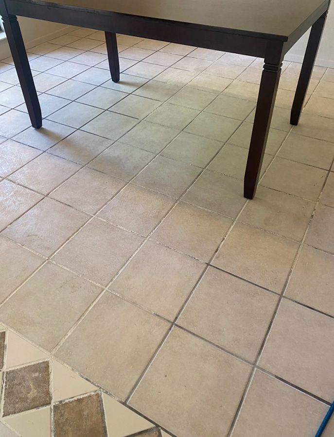 Dark brown table on tan square tiles.  Incomplete tile work in lower left.